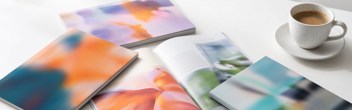 Magazines spread out on a white table with a cup of coffee and reading glasses
